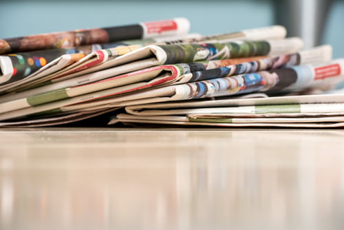 A collection of folded newspapers resting on a table