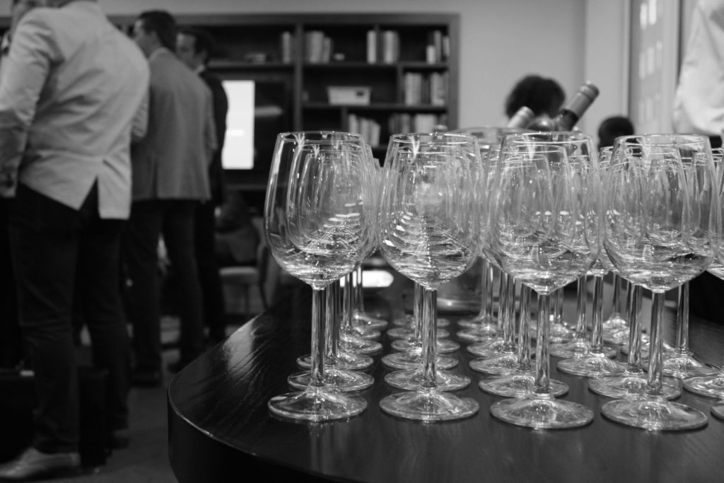 A black & white image of empty wine glasses lined up on a table